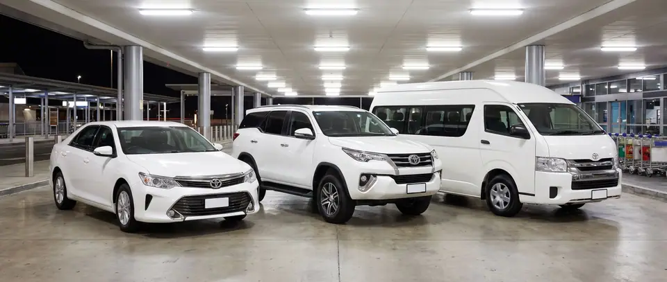 รถเก๋ง SUV และรถตู้ ที่จุดรับผู้โดยสารสนามบินยามค่ำ